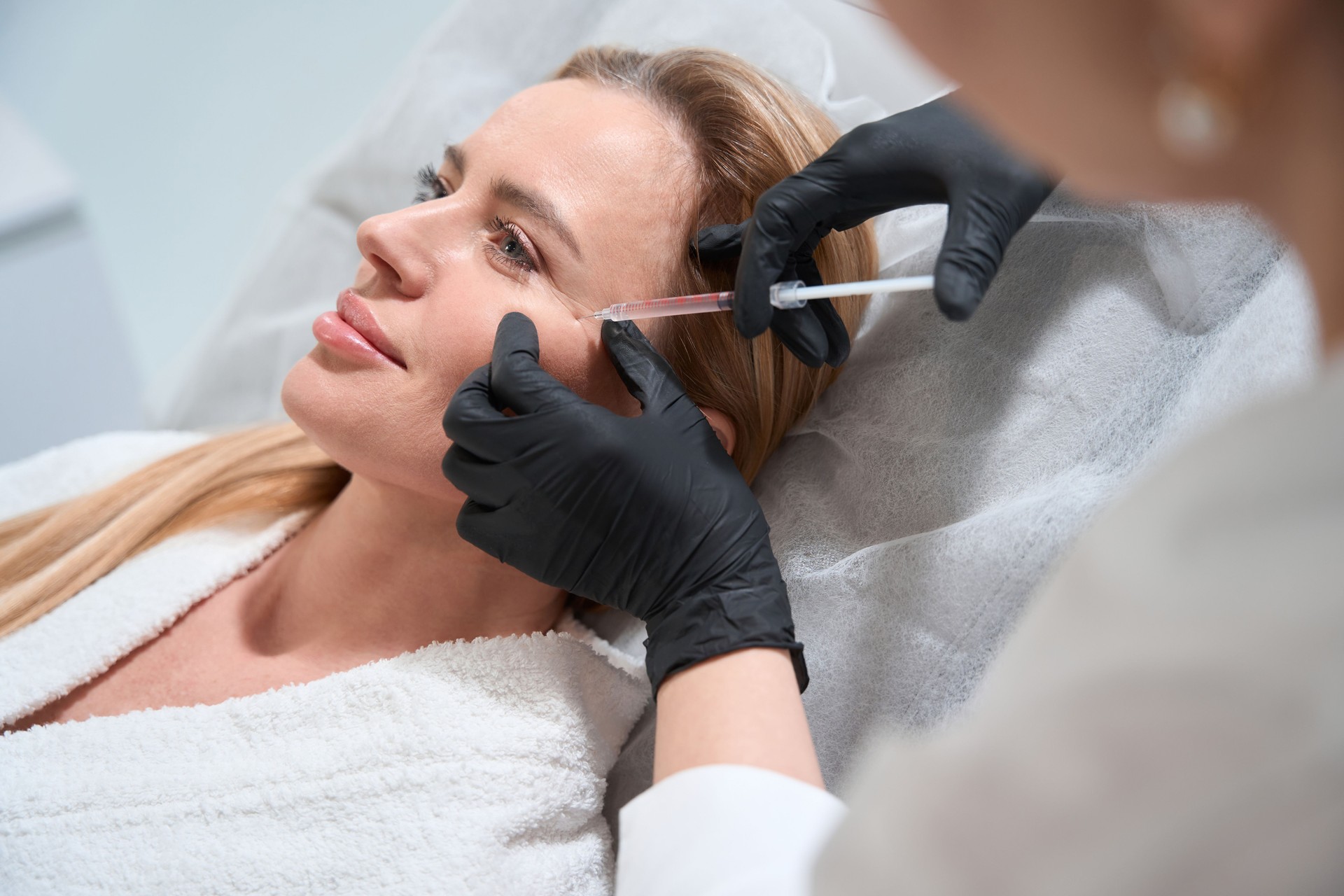 Female blonde gets a rejuvenating injection in her cheeks