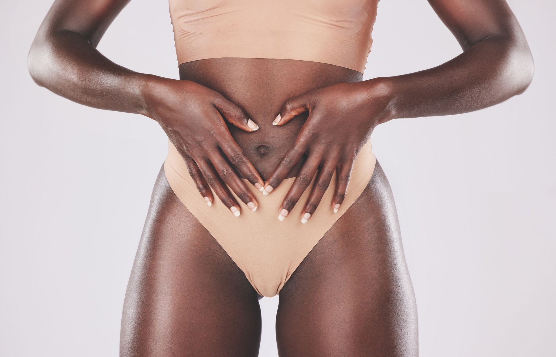 Healthy black woman, heart hands and stomach diet, weightloss wellness and gut health, body contouring and slimming on studio background. Fitness model abdomen, love and digestion, skincare and belly